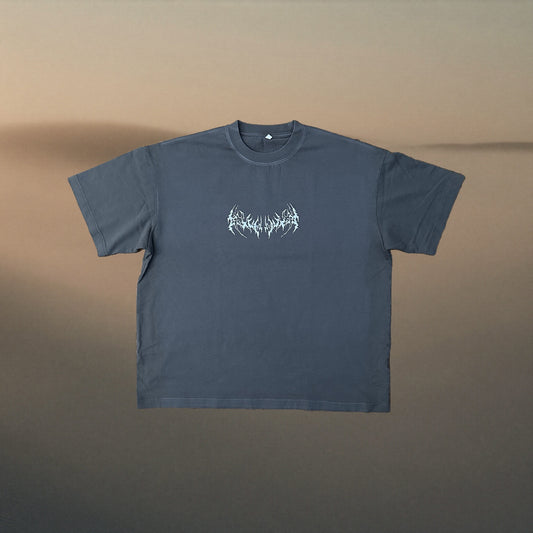 Charcoal tee with pale blue neo tribal chest print, warm sand fog backdrop